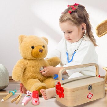 کودک در حال بازی نقش دکتر با ست پزشکی چوبی و معاینه عروسک